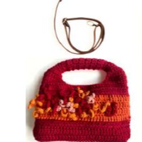 Sac à main au crochet fait main en coton rouge et orange orné de fleurs en relief multicolores, avec poignée intégrée, sur fond blanc.
Bandoulière en cuir cognac amovible et réglable