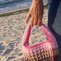 Luxury Anabaum Boxy bag held against a beach backdrop, highlighting the thick-gauge textured yarn