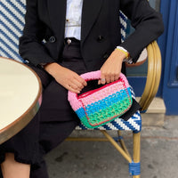 Designer Anabaum Boxy bag in pink and green technical crochet paired with a professional black blazer.