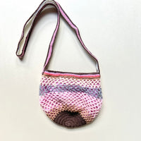 Full view of the Lil Sis Sandstorm crochet shoulder bag on a white background, rounded shape with multicolor pink, mauve and brown striped strap
