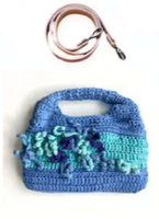Sac à main au crochet fait main en coton bleu ciel et  celadon, orné de fleurs en relief multicolores, avec poignée intégrée, sur fond blanc.

Bandoulière en cuir cognac amovible et réglable
