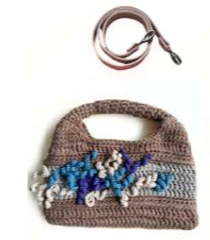 Sac à main au crochet fait main en coton dans les tons de sable, orné de fleurs en relief dans des tons parme et prune, avec poignée intégrée, sur fond rose blanc.
Bandoulière en cuir amovible et réglable.