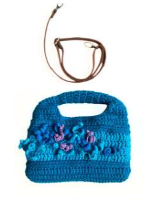 Sac à main au crochet fait main en coton bleu canard et turquoise, orné de fleurs en relief multicolores, avec poignée intégrée, sur fond blanc.

Bandoulière en cuir cognac amovible et réglable