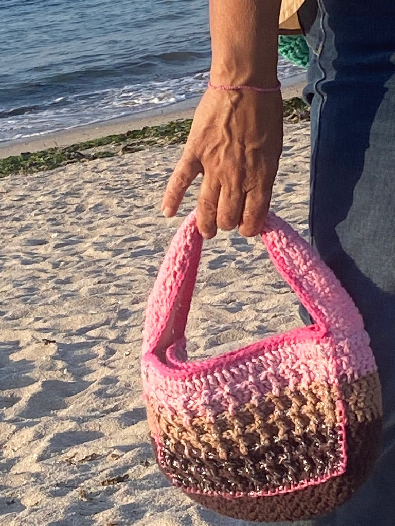 Luxury Anabaum Boxy bag held against a beach backdrop, highlighting the thick-gauge textured yarn
