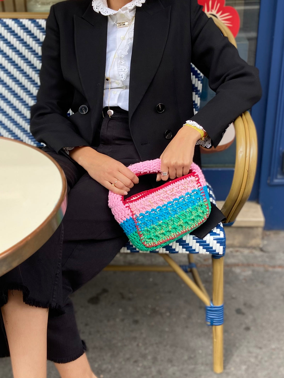 Designer Anabaum Boxy bag in pink and green technical crochet paired with a professional black blazer.