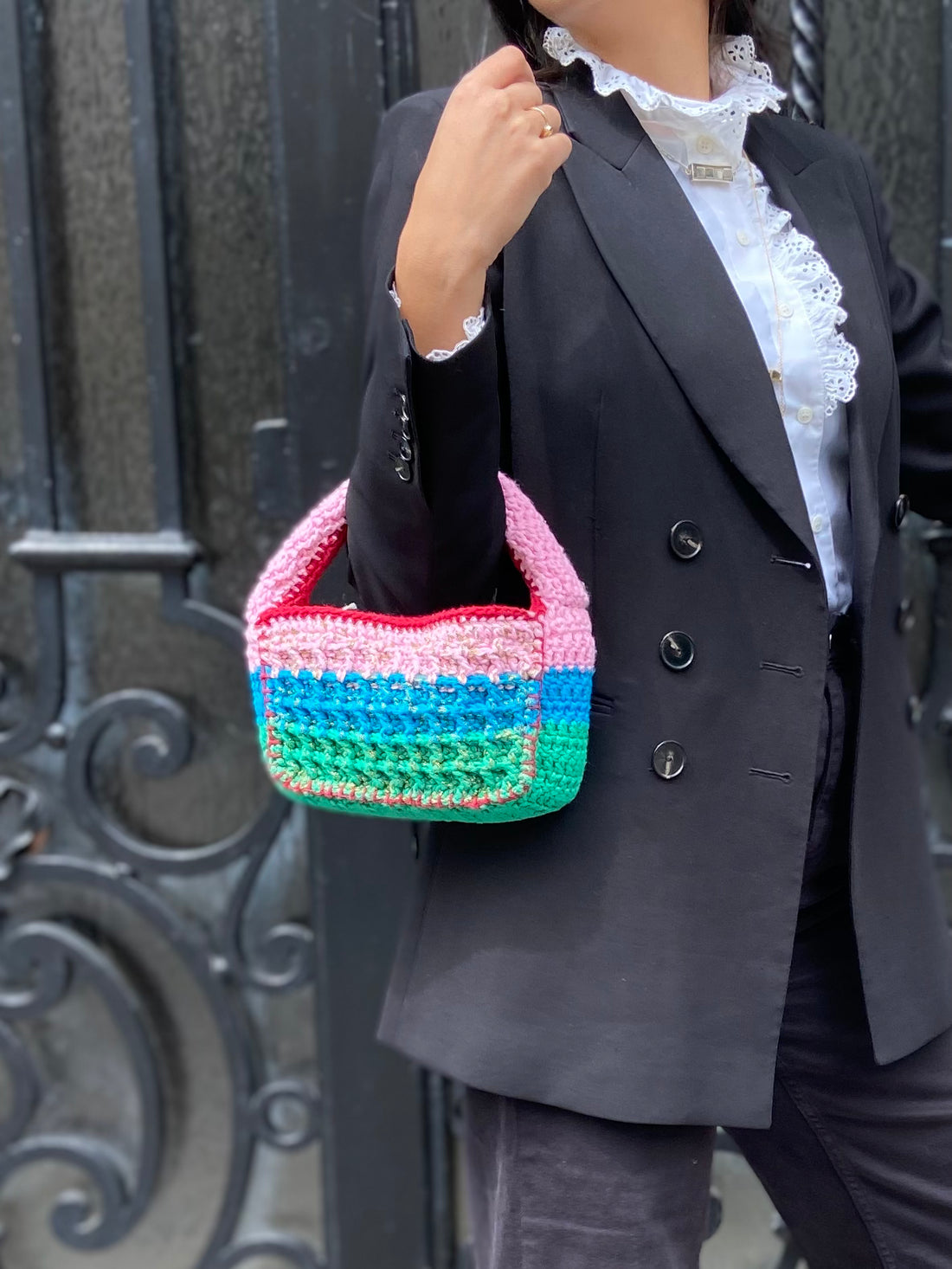 Designer Anabaum Boxy bag in pink and green technical crochet paired with a professional black blazer.