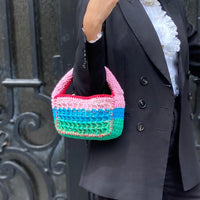 Designer Anabaum Boxy bag in pink and green technical crochet paired with a professional black blazer.