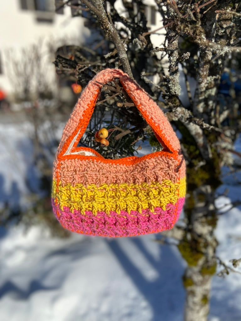 Close-up of the Anabaum Boxy Vibe bag's intricate waffle-stitch crochet pattern in premium pink to yellow to orange cord.