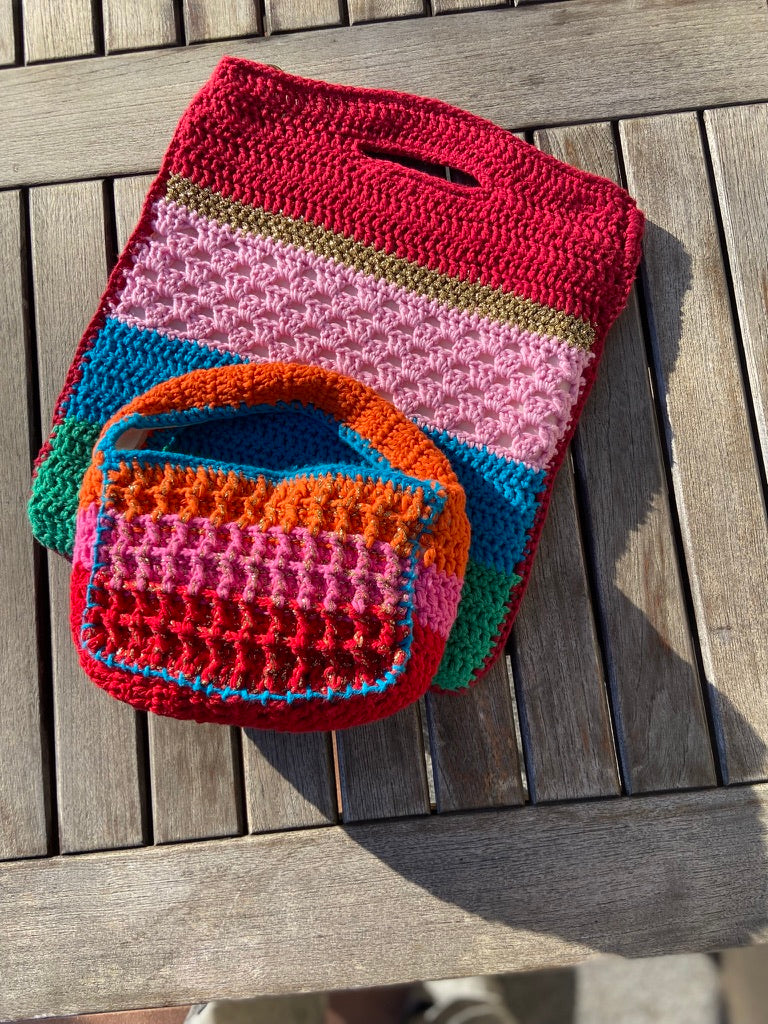 Upscale Anabaum Boxy bag in vibrant technical crochet on top of the Anabaum Shopper bag in matching vibrant colors.