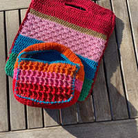 Upscale Anabaum Boxy bag in vibrant technical crochet on top of the Anabaum Shopper bag in matching vibrant colors.