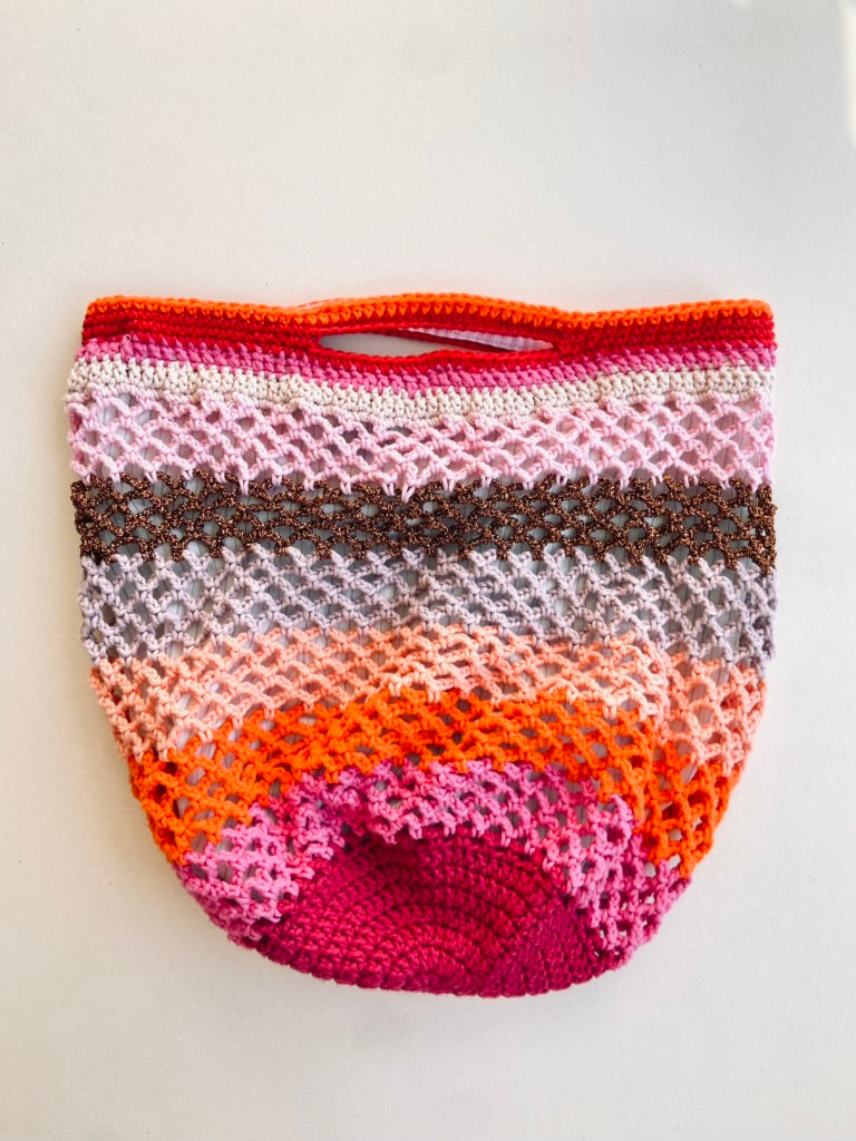 grand sac crochet multicolore Anabaum Maxi Vibe dans les couleurs aux rayures multicolores dans les roses et oranges, et texture ajourée livré avec une bandoulière amovible et réglable en cuir