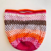 grand sac crochet multicolore Anabaum Maxi Vibe dans les couleurs aux rayures multicolores dans les roses et oranges, et texture ajourée livré avec une bandoulière amovible et réglable en cuir