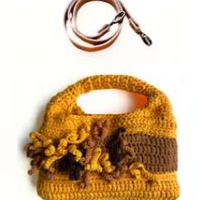 Sac à main au crochet fait main en coton jaune moutarde et marron, orné de fleurs en relief, avec poignée intégrée, sur fond blanc. Bandoulière en cuir cognac amovible et réglable