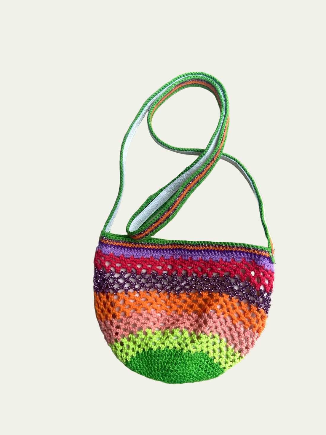 Full product view of the Lil Sis Funky crochet shoulder bag on a cream background, rounded shape with green strap and vibrant neon stripe pattern, designed in Paris by Anabaum
